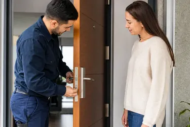 Chaveiro abrindo uma porta com ferramentas adequadas.